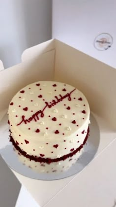 a birthday cake with white frosting and red sprinkles in a box