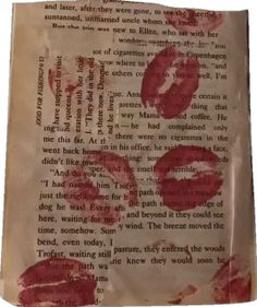 an old book with red lipstick on it and some words written in the pages below