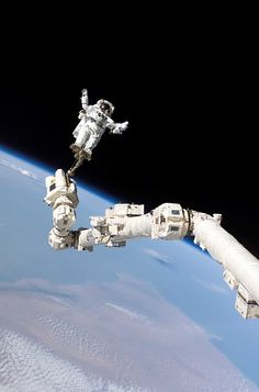 an astronaut floating in the air next to a space station attached to a satellite device