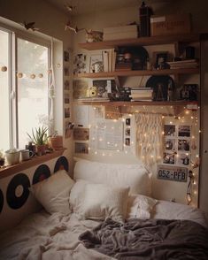 a bedroom with lots of lights and pictures on the wall above the bed, along with bookshelves