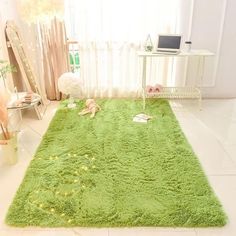 a green rug in the middle of a room with a laptop on top of it