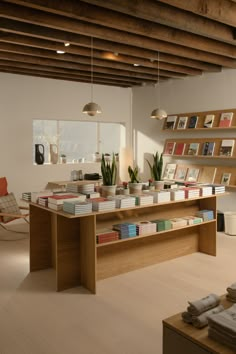 a room filled with lots of books on top of a wooden shelf next to a window