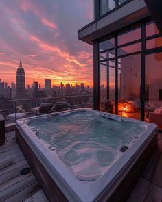 a hot tub sitting on top of a wooden floor next to a window with the city in the background