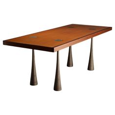 a wooden table with three metal legs and two knobs on each end, against a white background