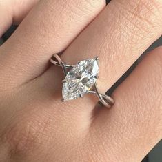 a woman's hand with a ring on her finger and a diamond in the middle