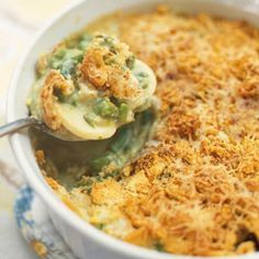 a casserole dish with green beans and cheese being scooped from the casserole