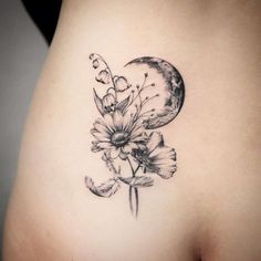 a woman's stomach with flowers and a moon on it