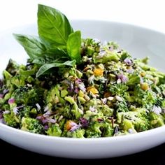 a white bowl filled with broccoli and sprouts on top of a table