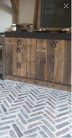 a kitchen area with an oven, counter top and wooden cabinets in the background that are made out of wood planks