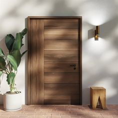 a potted plant sitting in front of a wooden door on a brick floor next to a white wall