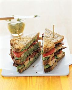 a sandwich cut in half sitting on top of a white plate with toothpicks