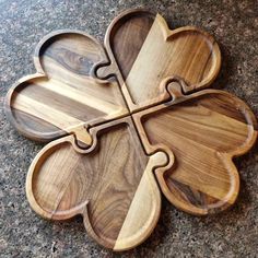 four pieces of wood are arranged in the shape of a clover on a granite surface