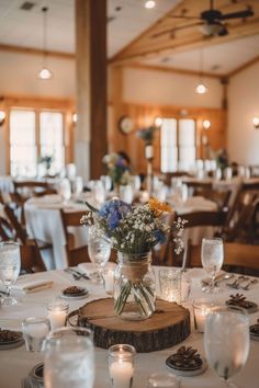 a table set with flowers and candles for a wedding or other function at the lodge