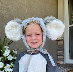 a young boy wearing a bear ears hat