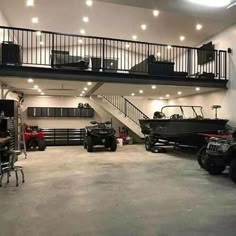 an open garage with several vehicles parked in front of it and stairs leading up to the second floor