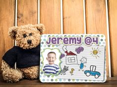 a teddy bear sitting next to a sign with a picture of a boy on it