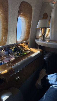 the inside of an airplane with two tables and lamps on each side of the seats