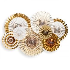 several decorative paper fans are arranged on a white background with gold and white designs in the center