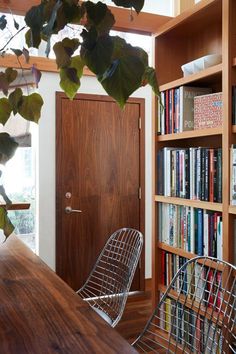 a wooden table sitting next to a book shelf filled with books