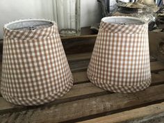 two lampshades sitting on top of a wooden crate in front of a mirror