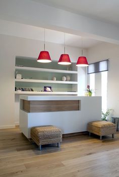 an empty room with two lamps hanging above the counter and stools on the floor