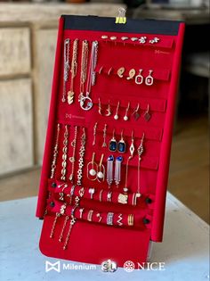 a red jewelry rack with lots of earrings on it