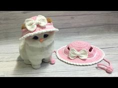 a crocheted cat is next to a hat and leash on a wooden floor