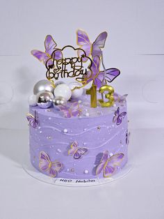 a birthday cake with purple frosting and butterflies on it's top is shown