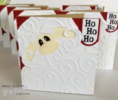 three christmas cards with santa's face on them