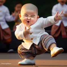 a small child with an excited look on his face and hands, standing in front of other children