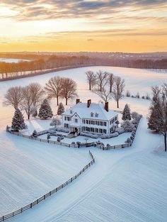 an aerial view of a large white house in the middle of a snow covered field