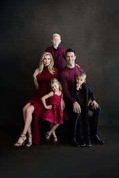 a family posing for a photo in front of a black background