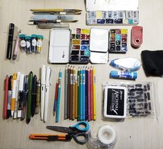 the contents of a craft kit laid out on top of a table with pens, scissors and markers