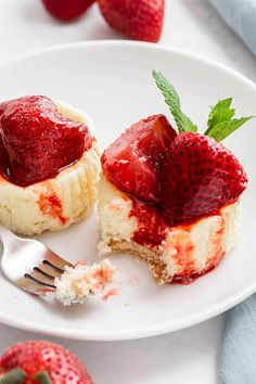 strawberry cheesecakes with whipped cream and fresh strawberries on the side, ready to be eaten