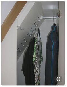 an open closet with clothes hanging from hooks