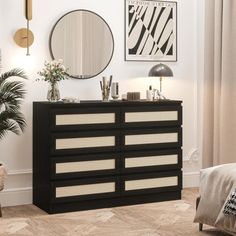 a black and white dresser sitting in a living room next to a mirror on the wall