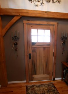 a wooden door in the corner of a room with an area rug on the floor