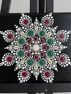 a painting on a black chair with white and red dots in the center, surrounded by circles