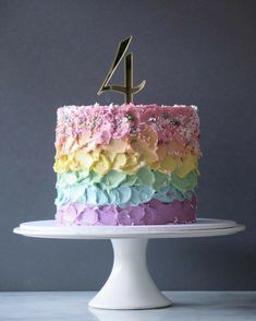 a cake that has the number four on it and is decorated with multicolored icing