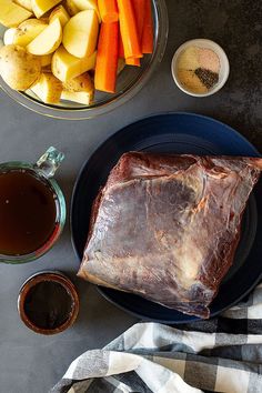 a plate with meat, potatoes and carrots on it next to some dipping sauce