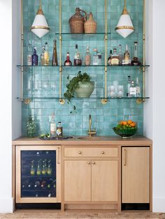 a bar with bottles and glasses on the top shelf next to a plant in a vase