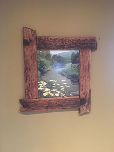 a wooden frame hanging on the side of a wall next to a toilet in a bathroom