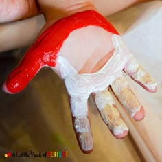 a person with red and white paint on their hands