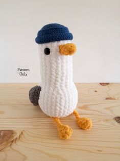 a crocheted bird with a blue hat on it's head and legs