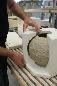 a man is making a vase out of clay