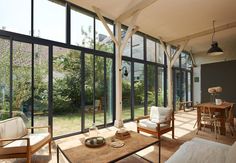 a living room filled with furniture and lots of glass doors that open up to the outside