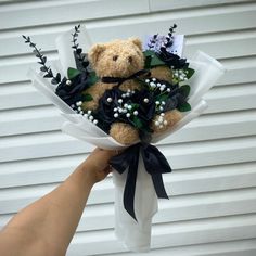 a teddy bear with flowers in its hand