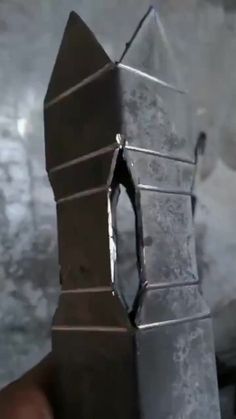 a piece of metal that is in the shape of a tower with a broken door