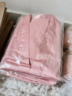 a pink shirt sitting on top of a pile of carpet