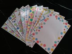 six envelopes with different designs on them sitting on top of a black countertop